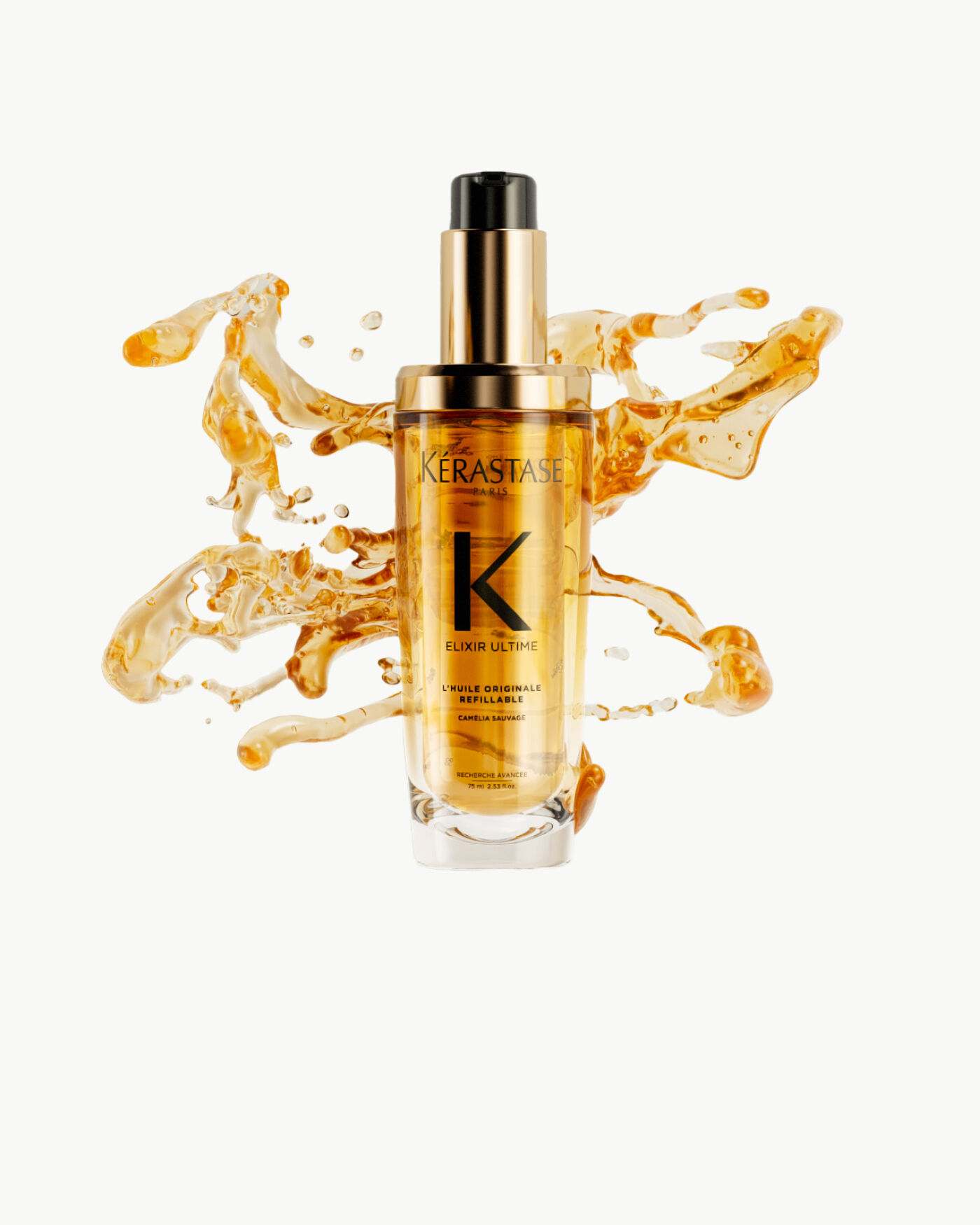 Frasco de suero Kerastase Elixir Ultime rodeado de gotas de aceite dorado sobre un fondo claro.