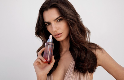 Frasco de serum Kerastase junto a una rosa roja, ilustrando el anclaje y la fijacion del cabello en la raiz