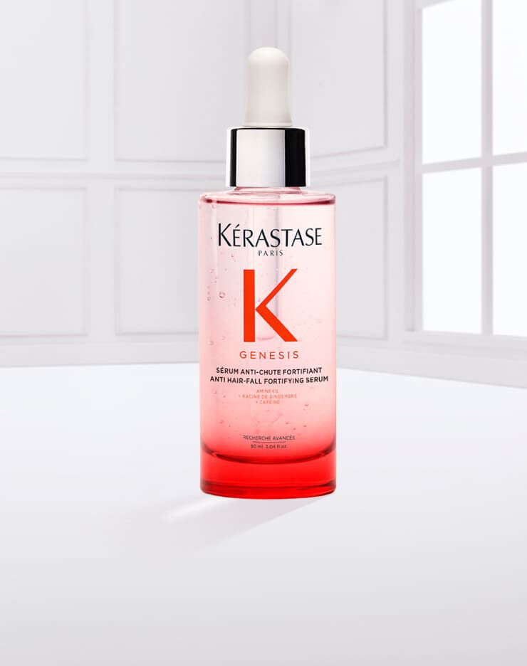 Botella de suero Kerastase Genesis, con un gotero blanco, sobre un fondo claro.