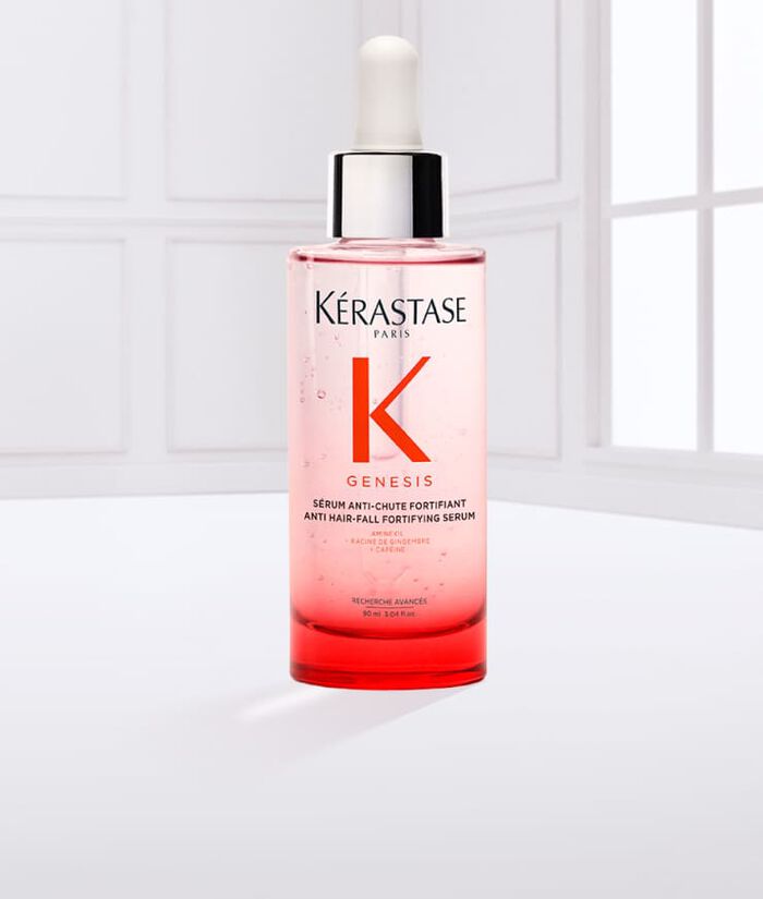 Botella de suero Kerastase Genesis, con un gotero blanco, sobre un fondo claro.