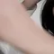 A close-up shot of a person brushing their hair in front of a mirror, with soft focus on their face and hand.