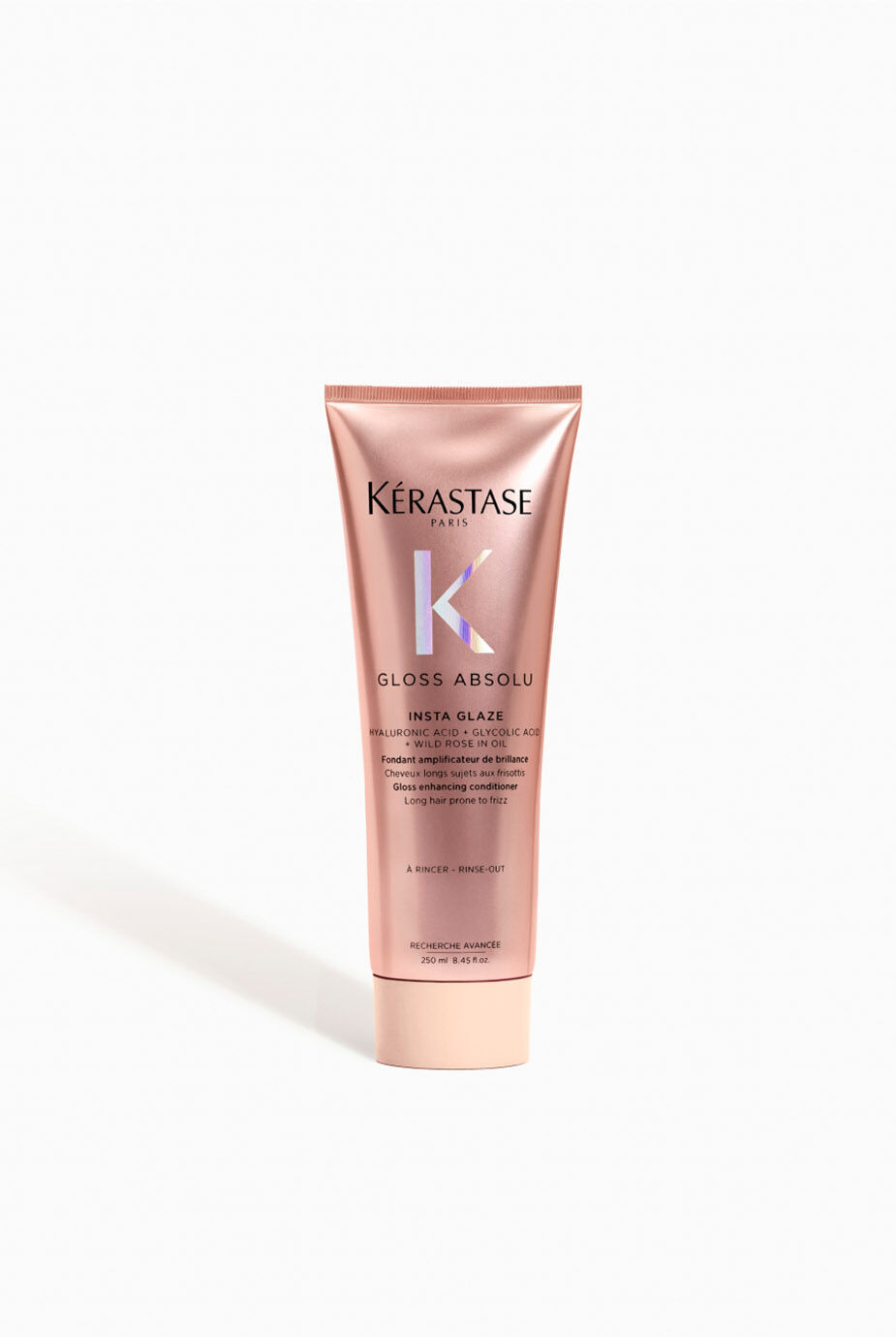 A pink tube of Kerastase Gloss Absolu Insta Glaze hair treatment with elegant branding and a white background.