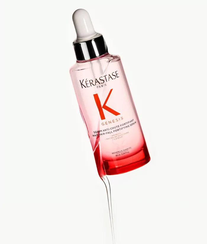 Botella de suero Kerastase Genesis, con un gotero blanco, sobre un fondo claro.
