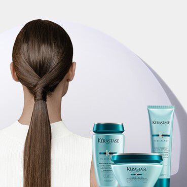 Mujer con coleta brillante y productos Kerastase Resistance turquesa.