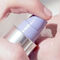 Close-up image of a hand pressing a pump bottle to dispense a creamy product.