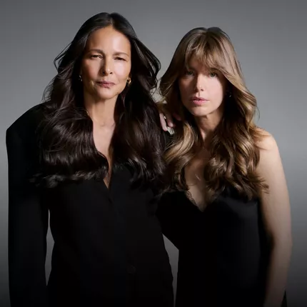 Dos mujeres de distintas generaciones vestidas de negro, ilustrando los habitos para mantener un cabello sano con el paso del tiempo