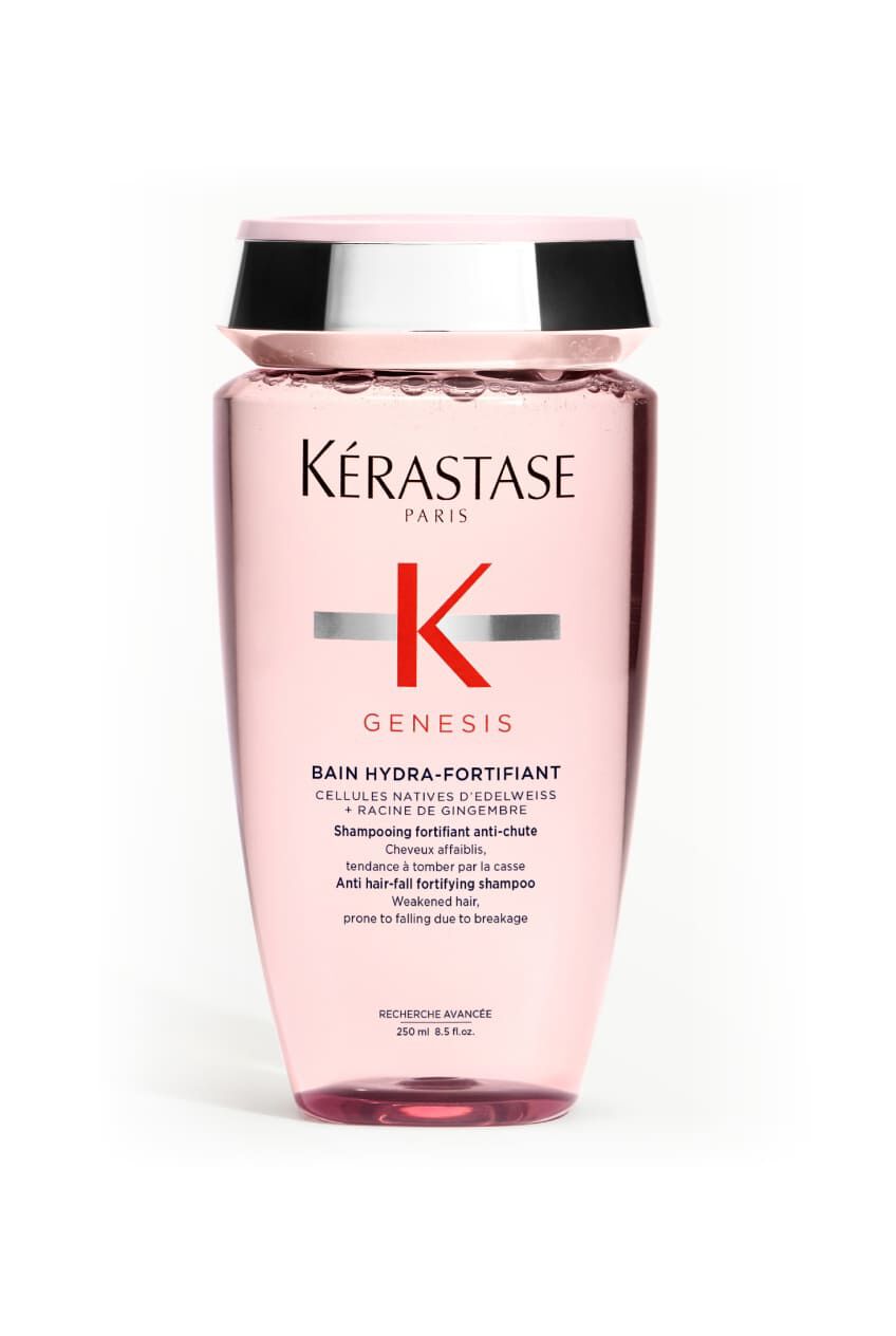Botella transparente rosa del champu Kerastase Genesis Bain Hydra-Fortifiant para cabello debilitado, inclinada.