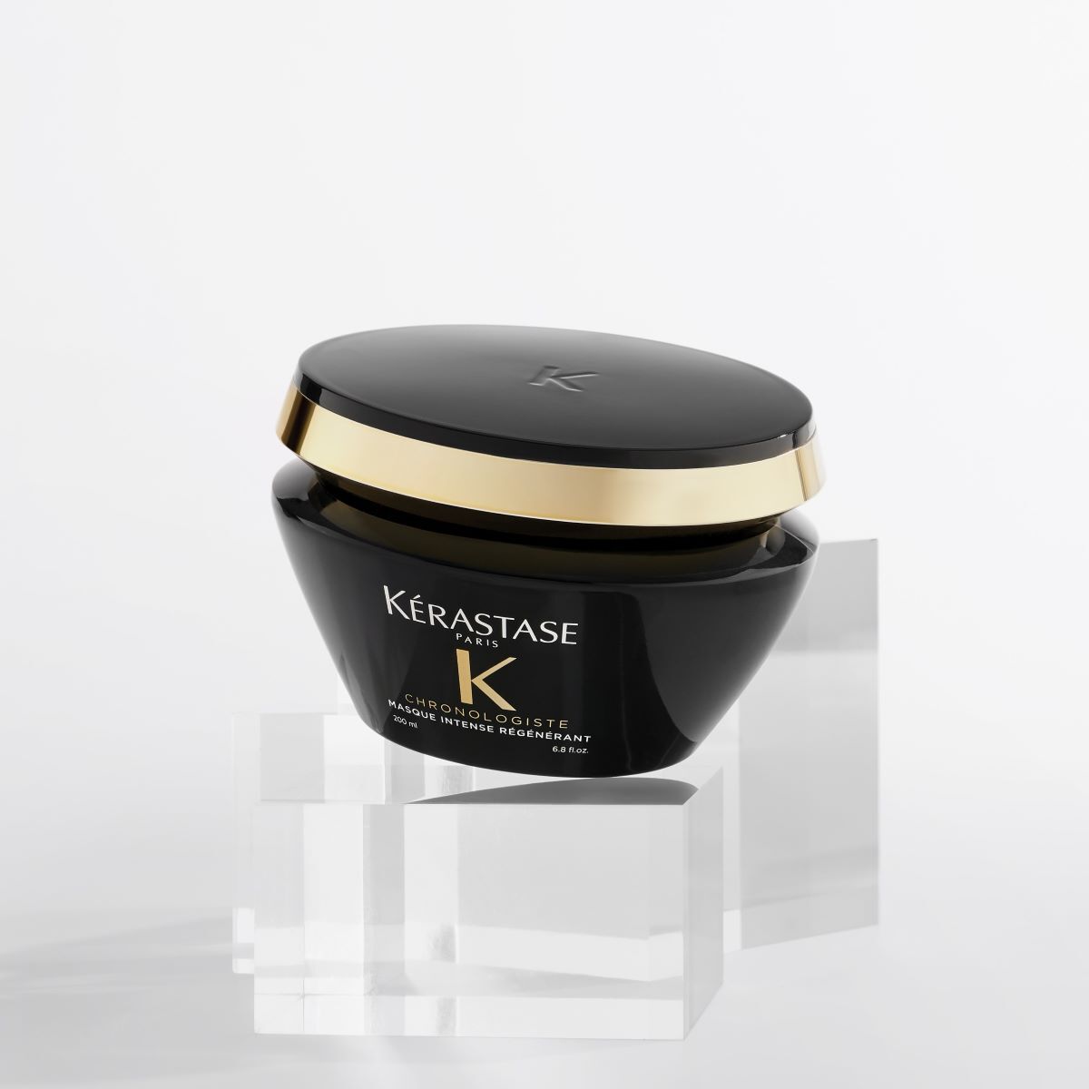 Frasco de crema capilar Kerastase Chronologiste en un fondo blanco, presentado sobre bloques de acrilico.