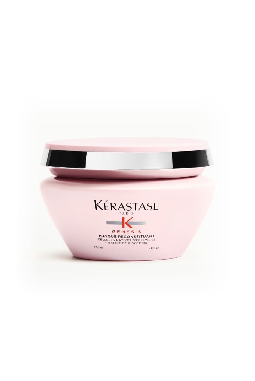 Tarro rosa de la mascarilla Kerastase Genesis Masque Reconstituant, sobre una superficie blanca.