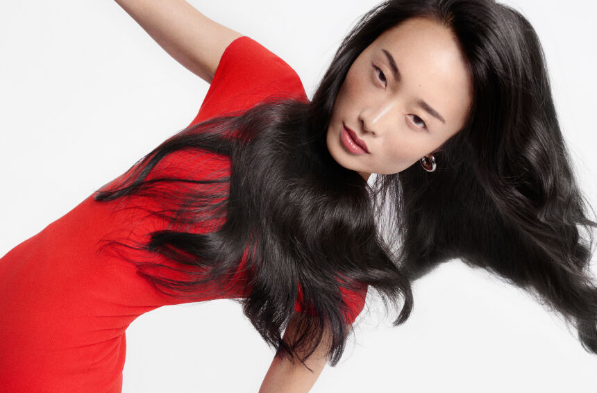 Mujer con top rojo y cabello oscuro suelto, ilustrando el diagnostico de una caida de cabello importante