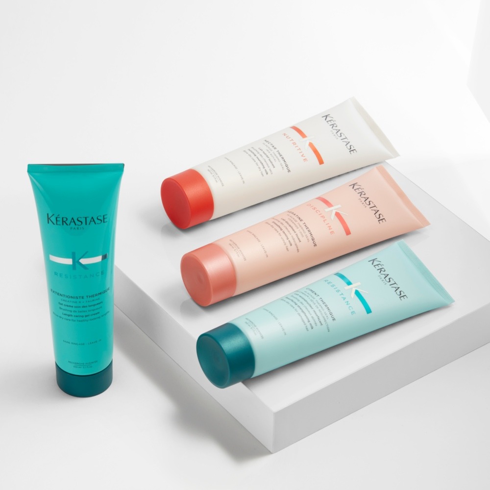 Nutritive, Discipline Résistance Thermique de Kérastase se presentan en una sencilla plataforma gris sobre fondo gris.