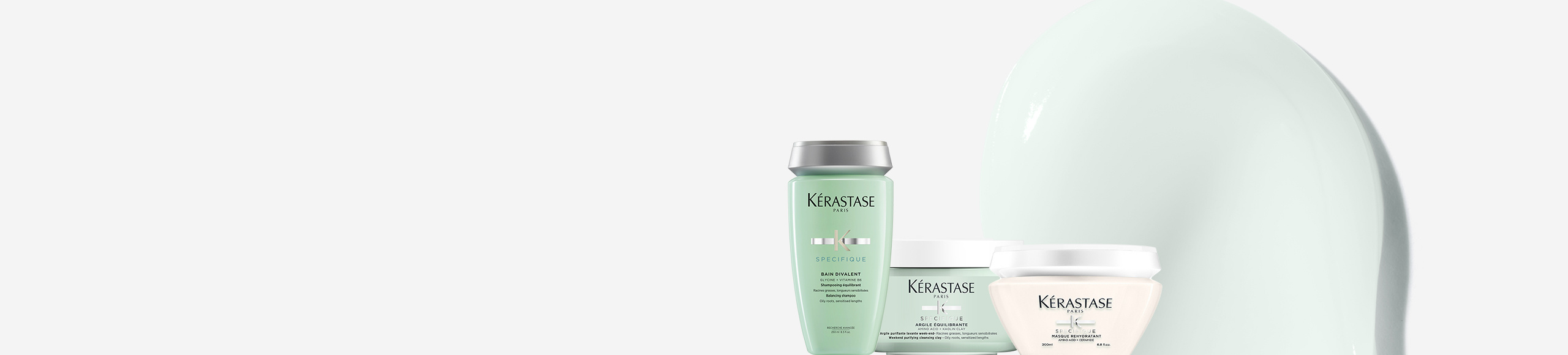 Productos de cuidado capilar de Kérastase en colores suaves, que incluyen champú, acondicionador y mascarilla.