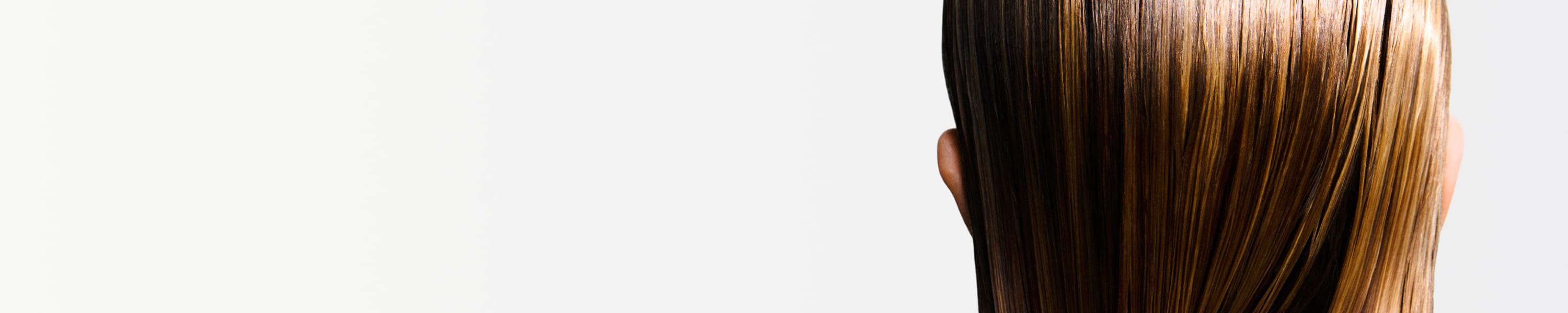 Mujer que aplica productos Kérastase sobre el cabello mojado