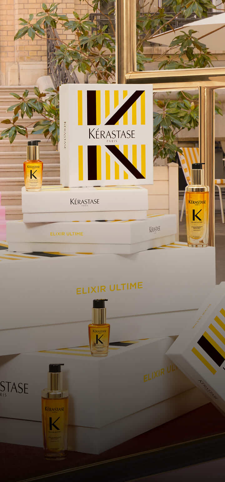 Cajas de Kérastase con botellas de Elixir Ultime, decoradas con un diseño elegante y moderno en un ambiente luminoso.