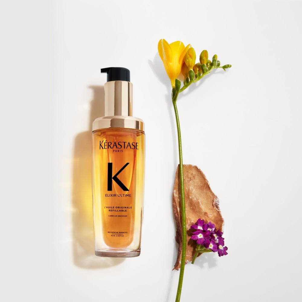 El nuevo Elixir Ultime recargable se presenta sobre un fondo gris puro con flores de fresia, heliotropo y sándalo.