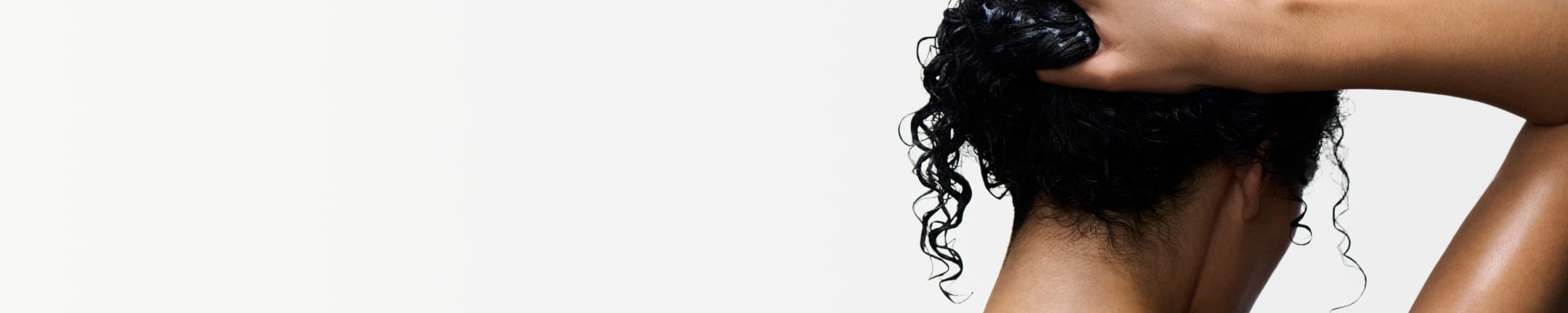 Mujer que aplica productos Kérastase sobre el cabello mojado
