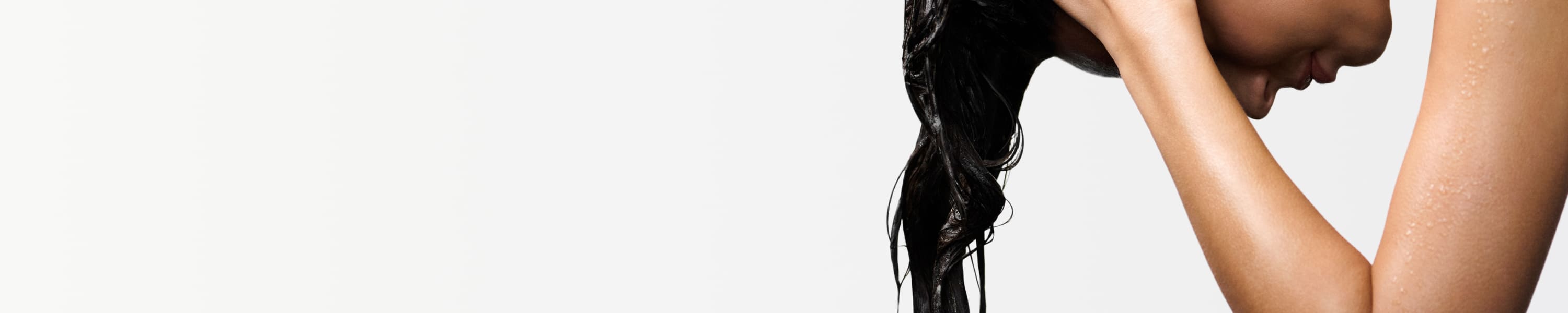 Mujer que aplica productos Kérastase sobre el cabello mojado