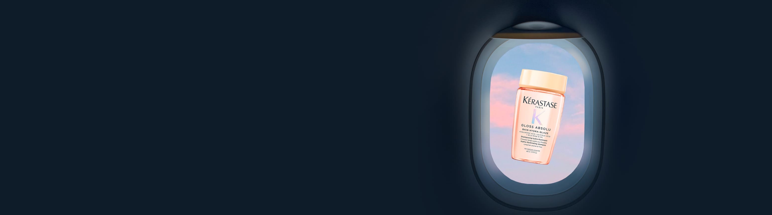 Frasco de viaje rosa translúcido de Kérastase Gloss Absolu Bain Hydra-Glaze, flotando en el centro de la ventanilla de un avión, con cielo pastel rosa y azul.